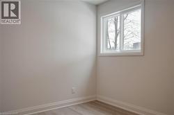 Unfurnished room featuring light wood-type flooring and baseboards - 