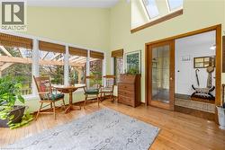 High-ceiling room featuring extensive window framing and wood-finish flooring - 