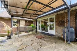 Covered patio featuring flagstone flooring, a transparent roof, and direct access to interior spaces via sliding glass doors - 