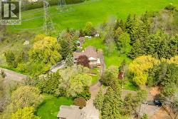 Expansive property featuring a brown-roofed residence with a multi-level deck, surrounded by mature trees and lush green landscaping - 