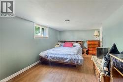 Bedroom featuring wood-finish flooring, light blue walls, and a recessed ceiling light - 