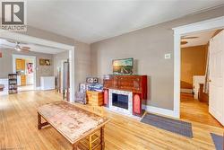 Wood-finish flooring throughout, featuring a decorative fireplace mantel with a tiled surround - 