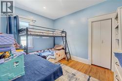 Interior room featuring wood-finish flooring, white trim, and a window with natural light - 