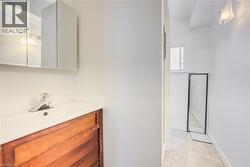 Bathroom vanity featuring a white integrated sink, wood-finish cabinetry, and a mirrored medicine cabinet - 