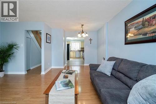 Open-concept living space with light wood-finish flooring, white baseboards, and a neutral wall color - 121 Morgan Avenue Unit# 7, Kitchener, ON 