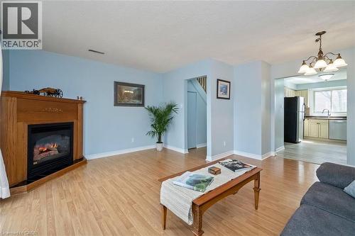 Living area featuring a corner fireplace with wood surround and mantle - 121 Morgan Avenue Unit# 7, Kitchener, ON 