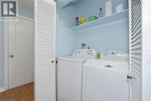Dedicated laundry closet featuring a built-in shelf, accordion-style louvered doors, and light blue wall finish - 121 Morgan Avenue Unit# 7, Kitchener, ON 