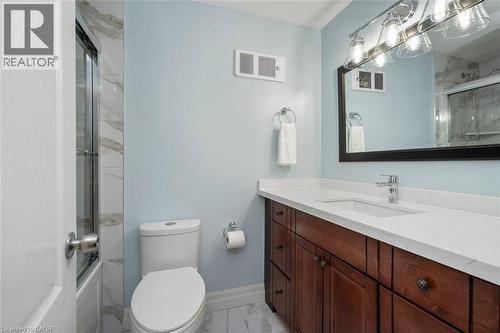 Contemporary bathroom featuring a dark wood-finish vanity with a white countertop and undermount sink - 121 Morgan Avenue Unit# 7, Kitchener, ON 