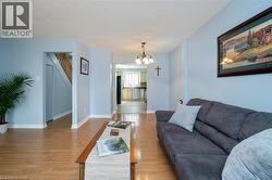 Open-concept living space with light wood-finish flooring, white baseboards, and a neutral wall color - 
