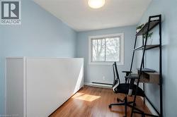 Light blue painted walls with a single window and wood-finish flooring - 