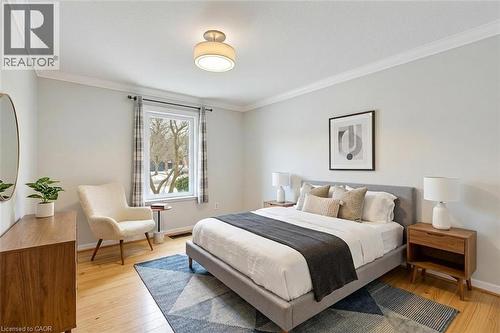 *VIRTUALLY STAGED* Bedroom featuring light wood-finish flooring, a contemporary semi-flush mount ceiling fixture, and bright crown molding - 44 Mcclellan Road, Alton, ON 