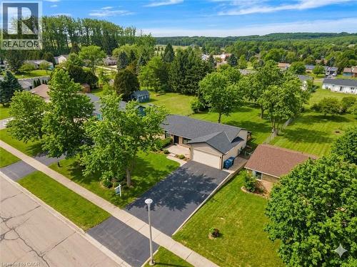 Single-story residence featuring a dark shingle roof, attached garage, and a paved driveway - 44 Mcclellan Road, Alton, ON 