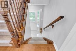 Staircase featuring wood-finish banisters and a carpeted runner - 