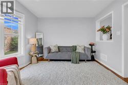 Bright interior space featuring light gray walls, wood-finish flooring, and a large window with horizontal blinds - 