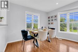 Dining area featuring wood-finish flooring, recessed lighting, and two large windows with white trim - 