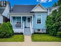Light blue siding exterior with a dark shingle roof and white trim accents - 58 East 22Nd Street, Hamilton, ON 