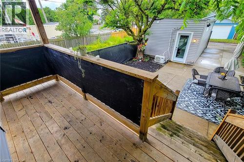 Multi-level wooden deck with natural wood railings, overlooking a concrete patio area - 58 East 22Nd Street, Hamilton, ON 