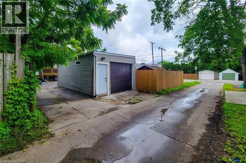 Detached garage featuring horizontal siding, an overhead door, and a separate service door - 58 East 22Nd Street, Hamilton, ON 