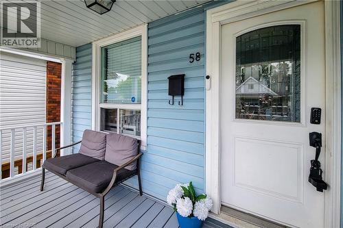 Covered porch featuring light blue siding and grey floorboards - 58 East 22Nd Street, Hamilton, ON 