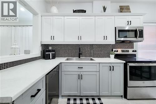 Contemporary kitchen featuring two-tone cabinetry with matte black hardware - 58 East 22Nd Street, Hamilton, ON 