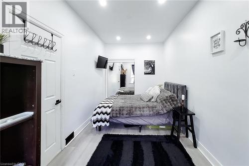 Bedroom featuring light wood-finish flooring, recessed lighting, and a mirrored closet - 58 East 22Nd Street, Hamilton, ON 