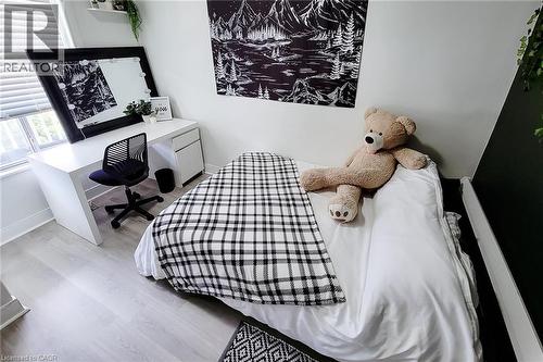 Bright bedroom featuring light wood-finish flooring and a window with blinds - 58 East 22Nd Street, Hamilton, ON 