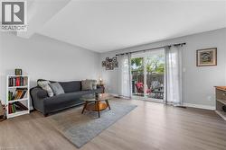 Open concept living area featuring light wood-finish flooring, light gray walls, and white trim - 