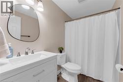 Bathroom featuring a white vanity with integrated sink, chrome faucet, and a contemporary frameless mirror - 