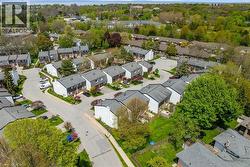 Aerial perspective of a residential community featuring townhomes with asphalt shingle roofs - 