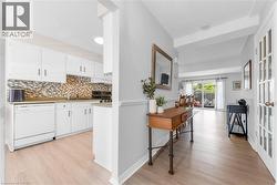 Light wood-finish flooring extends through the main living areas, complemented by a pale gray wall color - 
