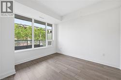 Bright room featuring expansive windows with white trim, wood-finish flooring, white baseboards, and neutral wall tones - 