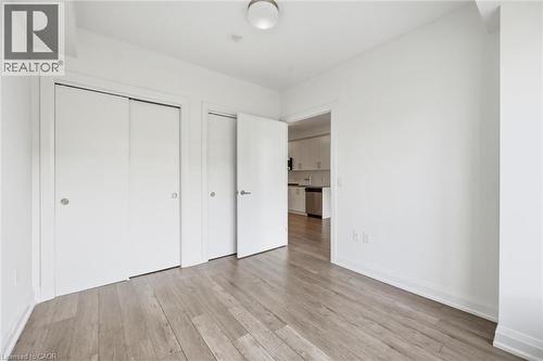 Light wood-finish flooring extending from the entryway - 212 King William Street Unit# 418, Hamilton, ON 