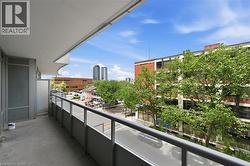 Private balcony with concrete flooring, glass panel railings, and urban streetscape - 