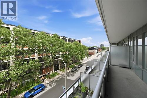 Expansive balcony featuring a concrete floor and metal railings with frosted panel inserts - 212 King William Street Unit# 418, Hamilton, ON 