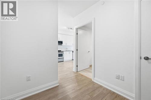 White-painted interior walls with wood-finish flooring - 212 King William Street Unit# 418, Hamilton, ON 