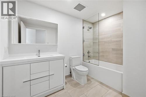 Modern bathroom featuring a single vanity with storage, an integrated sink, and a rectangular mirror - 212 King William Street Unit# 418, Hamilton, ON 