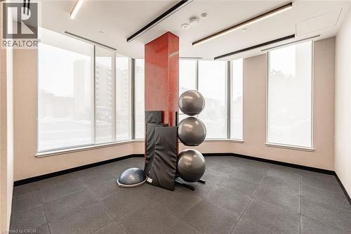 Dedicated fitness area featuring dark gray rubber flooring and a red accent column - 212 King William Street Unit# 418, Hamilton, ON 