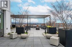 Expansive rooftop patio featuring a slatted pergola structure - 