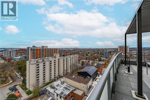 Curved balcony with glass and metal railing, providing elevated city and water views - 212 King William Street Unit# 418, Hamilton, ON 