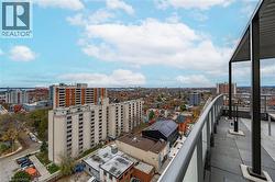Curved balcony with glass and metal railing, providing elevated city and water views - 