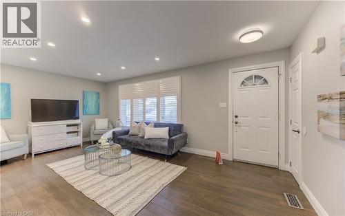 Spacious living area featuring rich wood-finish flooring and neutral wall tones - 619 Forest Hill Drive, Kitchener, ON 