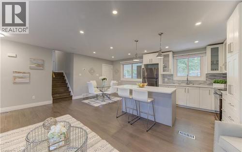 Open-concept living space featuring wood-finish flooring, recessed lighting, and a modern kitchen - 619 Forest Hill Drive, Kitchener, ON 