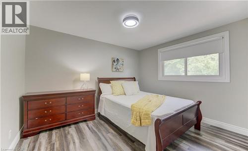 Room featuring wood-finish flooring, a window with white trim, and a ceiling-mounted light fixture - 619 Forest Hill Drive, Kitchener, ON 