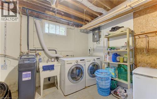 Dedicated laundry area featuring a utility sink, a window, exposed ceiling joists, and a water softener system - 619 Forest Hill Drive, Kitchener, ON 