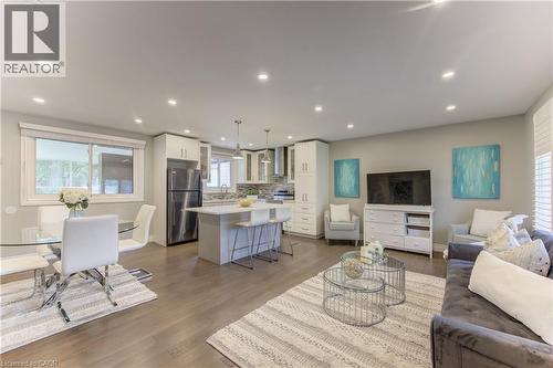 Open-concept living space featuring wood-finish flooring, recessed lighting, and white plantation shutters - 619 Forest Hill Drive, Kitchener, ON 