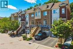 Townhome exterior featuring brick and stone cladding, gabled dormers, and multiple windows - 