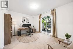 Carpeted room featuring a white ceiling and walls with white baseboards - 