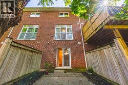 Brick exterior featuring a ground-level patio, private yard with wood fencing, and a multi-level wood deck - 