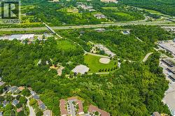 Extensive treed landscape featuring a baseball diamond, green recreational areas, and winding access roads - 