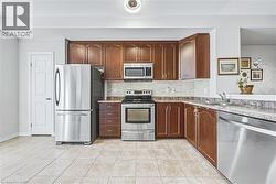 Full kitchen featuring wood cabinetry and stainless steel appliances - 